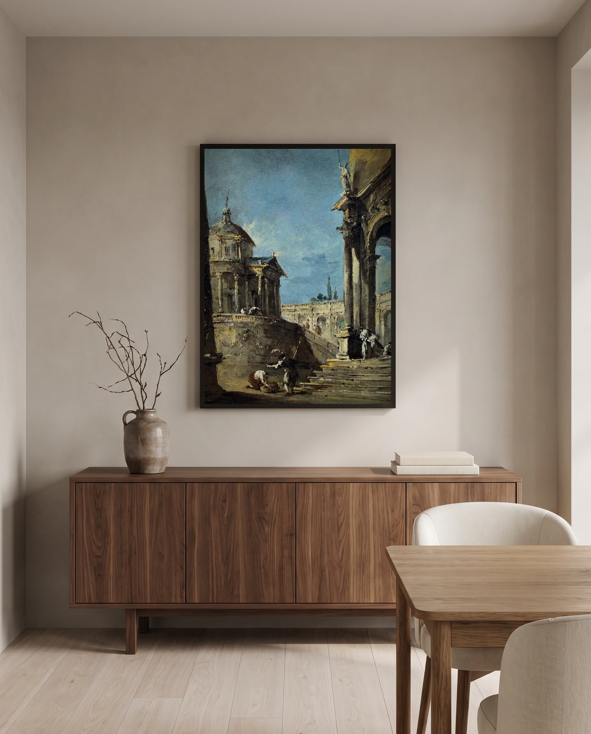 An Architectural Caprice by Francesco Guardi in a black frame above a walnut sideboard in a dining room