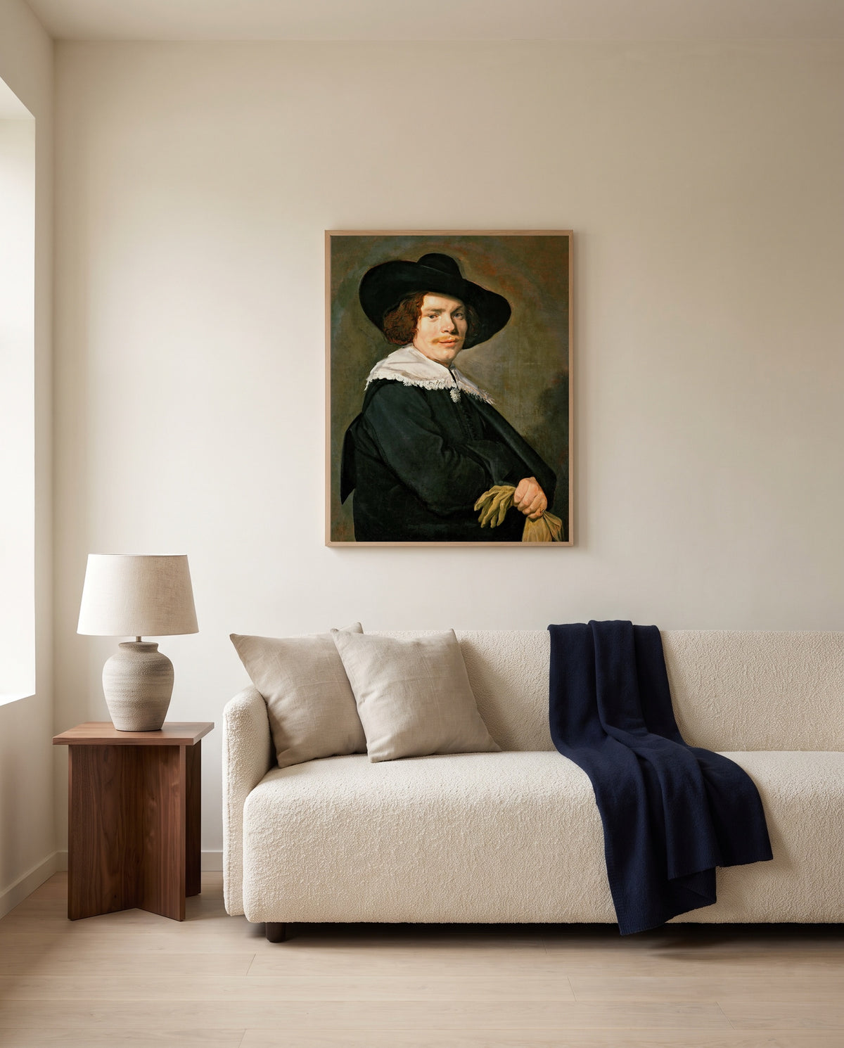 Portrait of a Young Man by Frans Hals framed in natural oak above a cream sofa in a warm living room