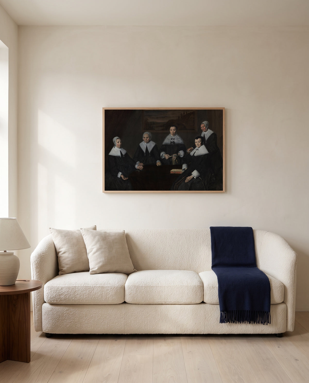 The Regentesses by Frans Hals framed in natural oak above a cream sofa in a warm living room