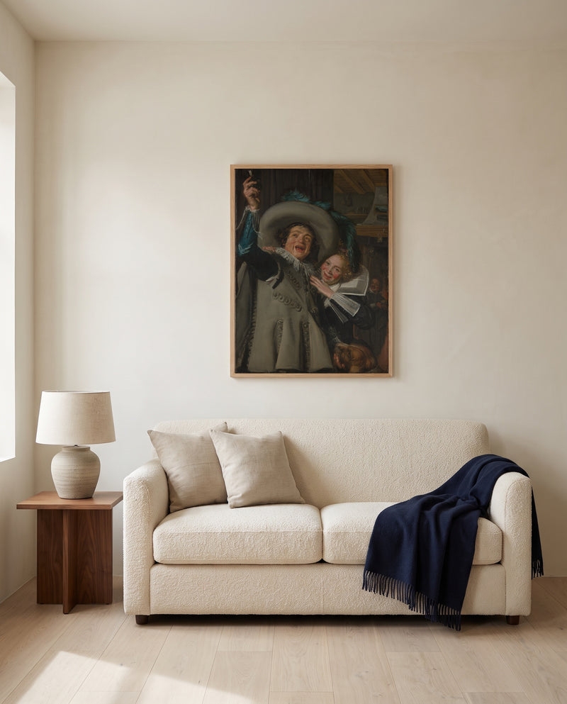 Young Man and Woman by Frans Hals framed in natural oak above a cream sofa in a warm living room