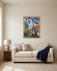 Blue Horse I by Franz Marc framed in natural oak above a cream sofa in a warm living room