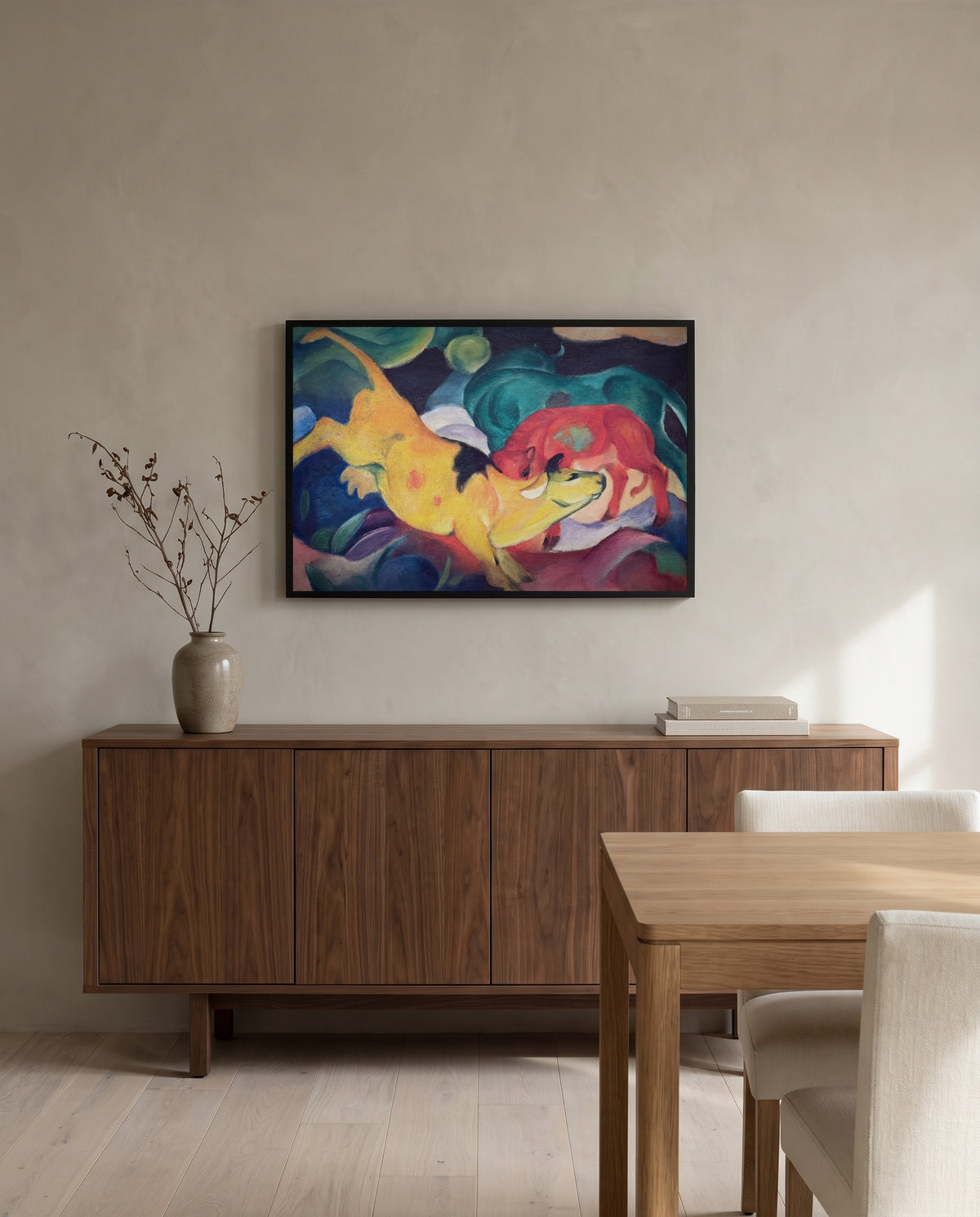 Cows, Red, Green, Yellow by Franz Marc in a black frame above a walnut sideboard in a dining room