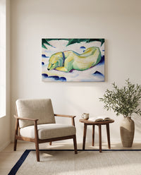 Dog Lying in the Snow by Franz Marc as a stretched canvas above a linen lounge chair in a reading corner