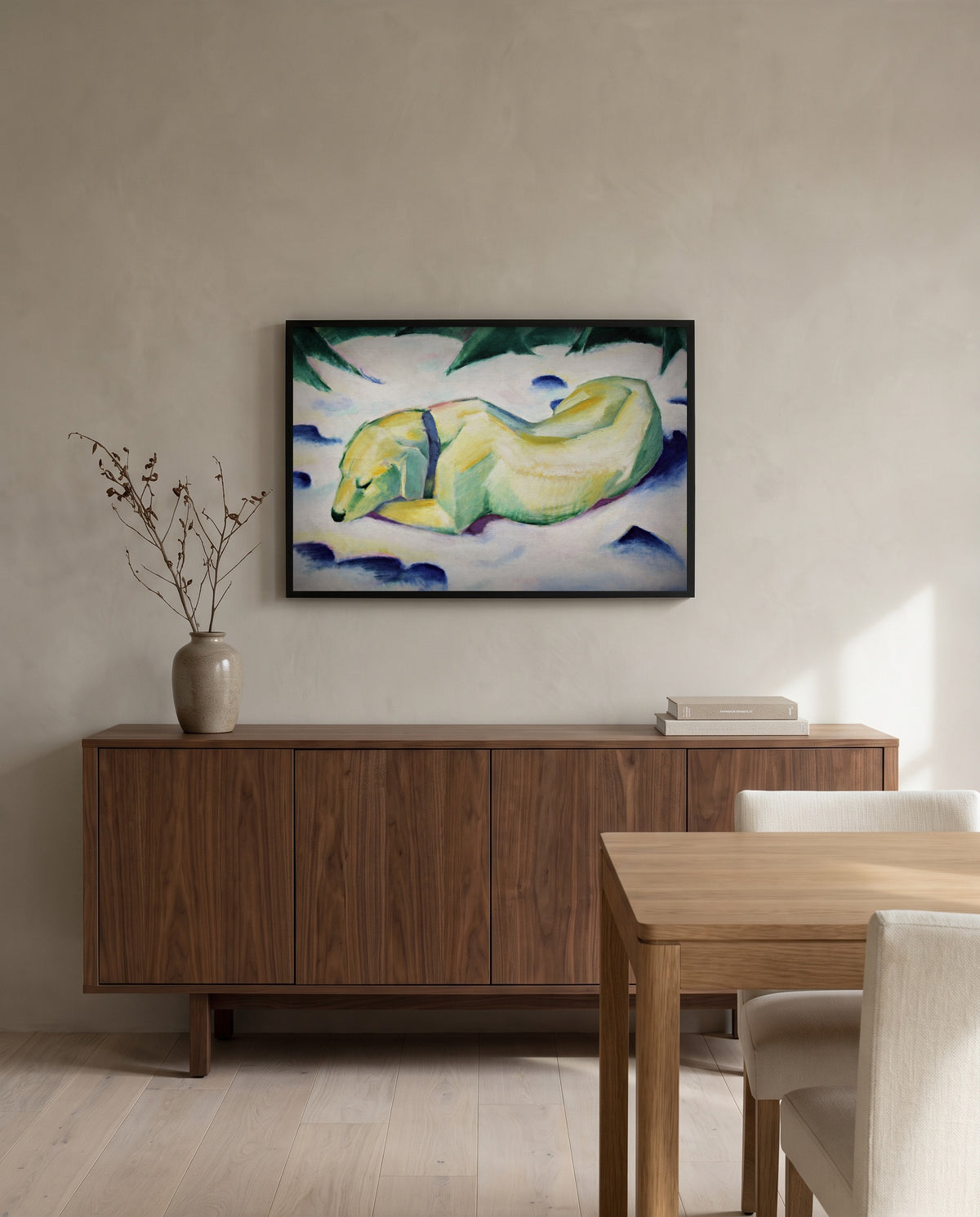 Dog Lying in the Snow by Franz Marc in a black frame above a walnut sideboard in a dining room