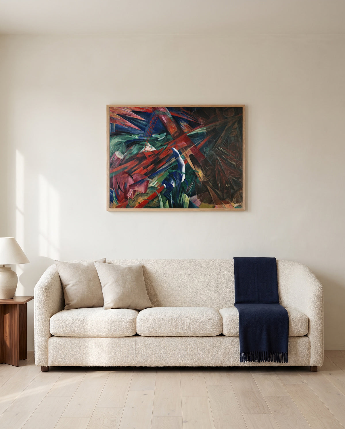 Fate of the Animals by Franz Marc framed in natural oak above a cream sofa in a warm living room
