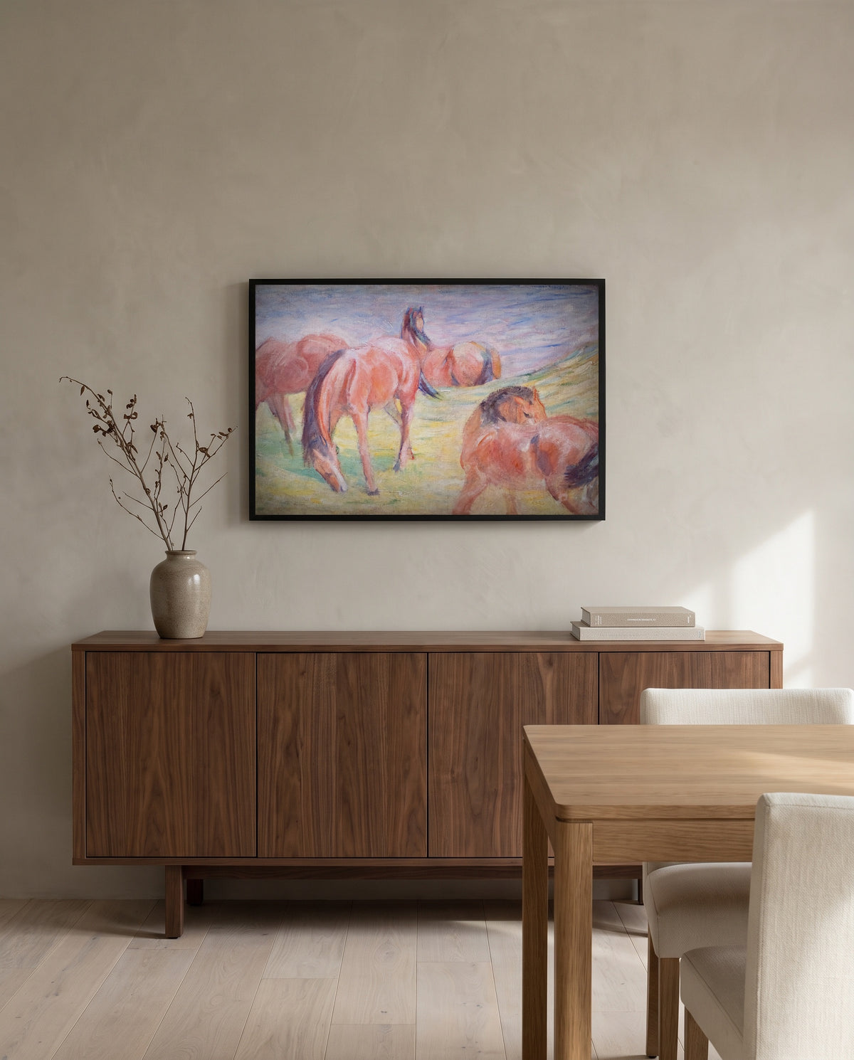 Grazing Horses I by Franz Marc in a black frame above a walnut sideboard in a dining room