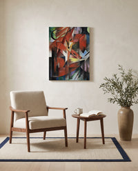The Foxes by Franz Marc as a stretched canvas above a linen lounge chair in a reading corner