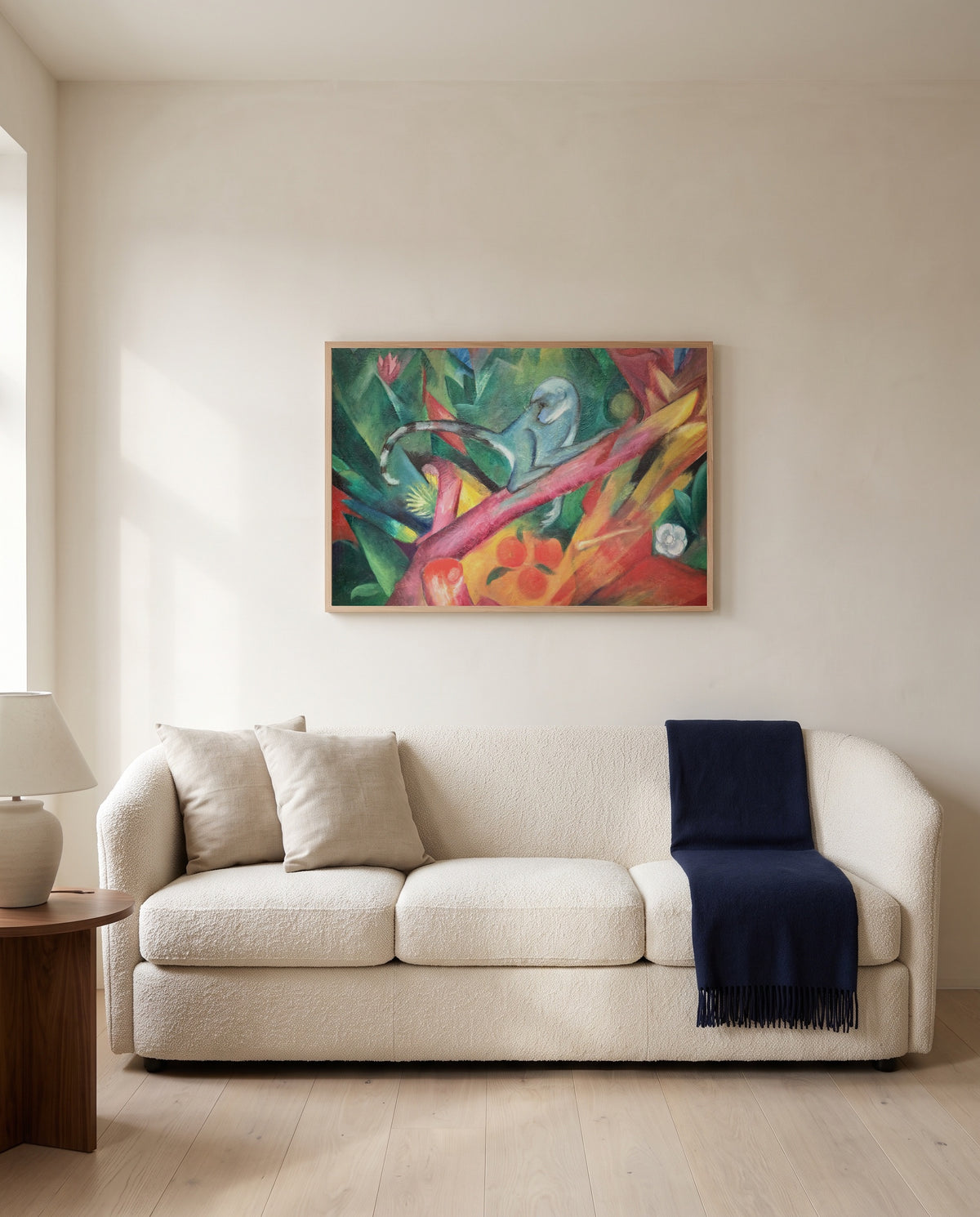 The Little Monkey by Franz Marc framed in natural oak above a cream sofa in a warm living room
