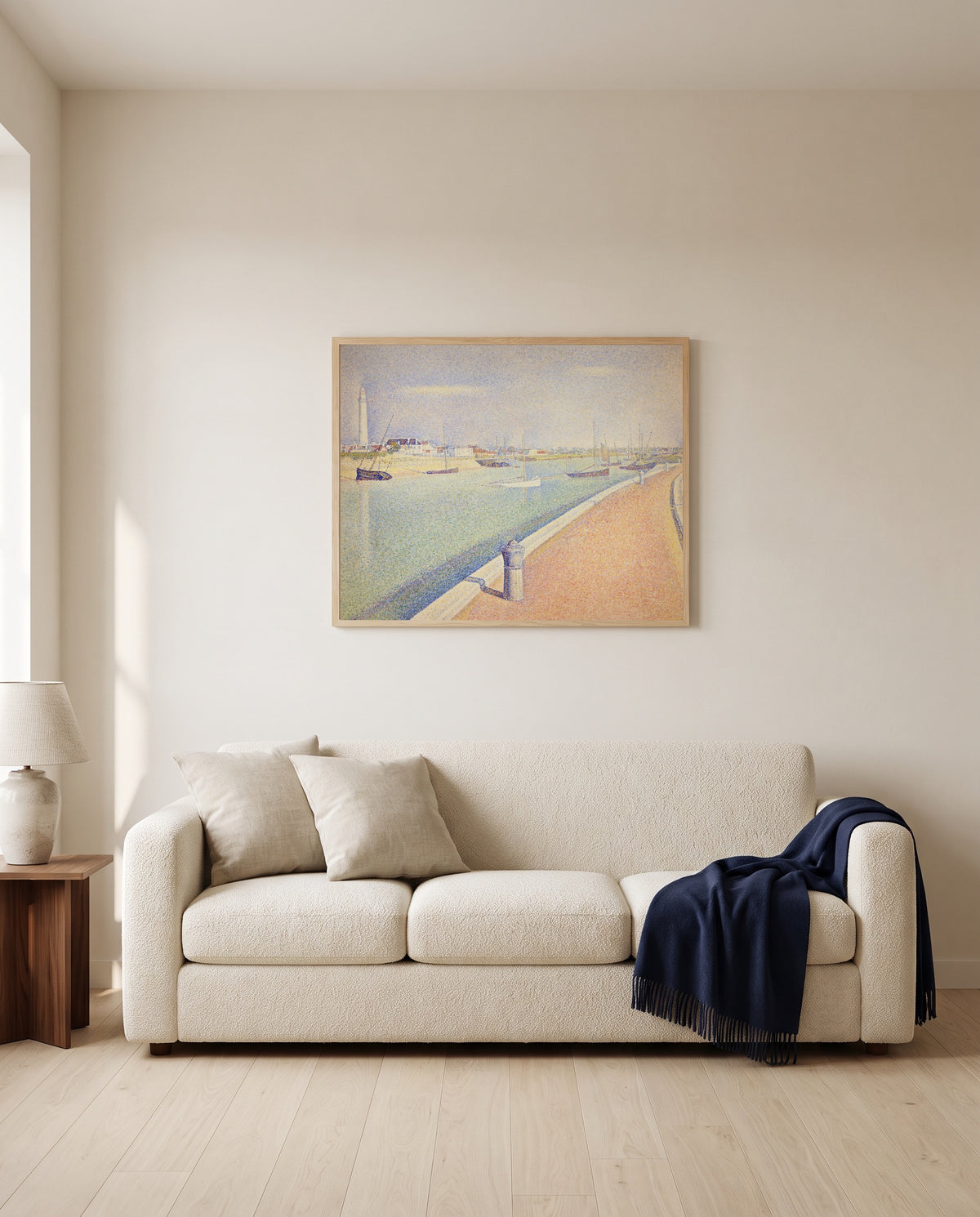 The Channel of Gravelines by Georges Seurat framed in natural oak above a cream sofa in a warm living room