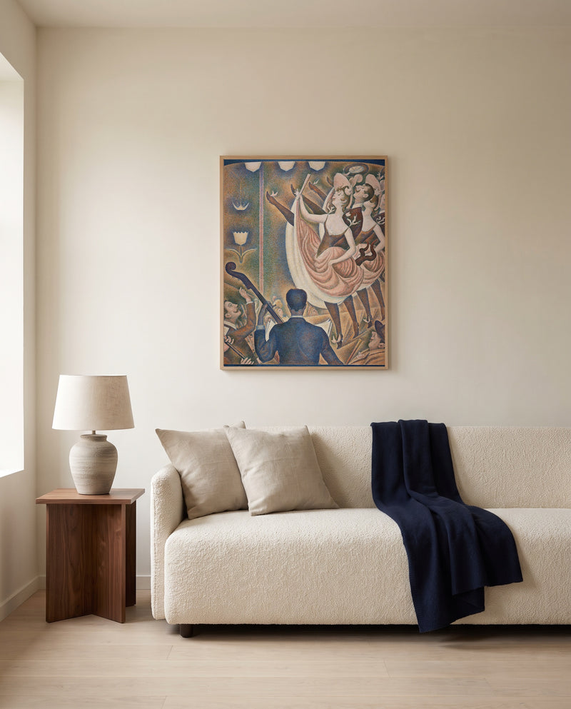 Le Chahut by Georges Seurat framed in natural oak above a cream sofa in a warm living room