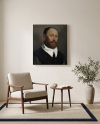 Man with Raised Eyebrows by Giovanni Battista Moroni as a stretched canvas above a linen lounge chair in a reading corner