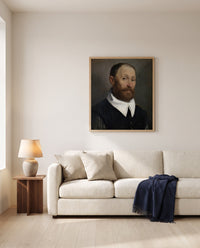 Man with Raised Eyebrows by Giovanni Battista Moroni framed in natural oak above a cream sofa in a warm living room
