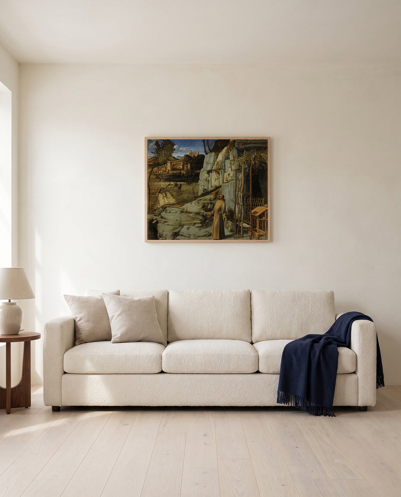 St Francis in the Desert by Giovanni Bellini framed in natural oak above a cream sofa in a warm living room