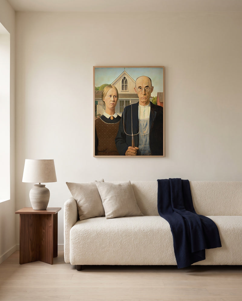 American Gothic by Grant Wood framed in natural oak above a cream sofa in a warm living room