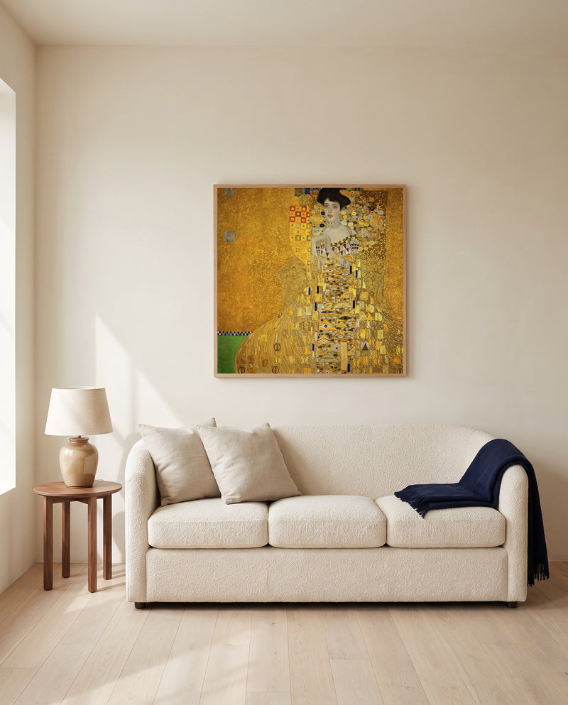Adele Bloch-Bauer I by Gustav Klimt framed in natural oak above a cream sofa in a warm living room