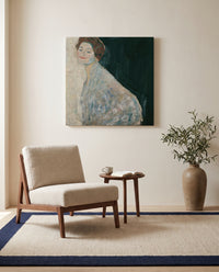 Lady in White by Gustav Klimt as a stretched canvas above a linen lounge chair in a reading corner