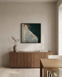 Lady in White by Gustav Klimt in a black frame above a walnut sideboard in a dining room