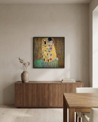 The Kiss by Gustav Klimt in a black frame above a walnut sideboard in a dining room