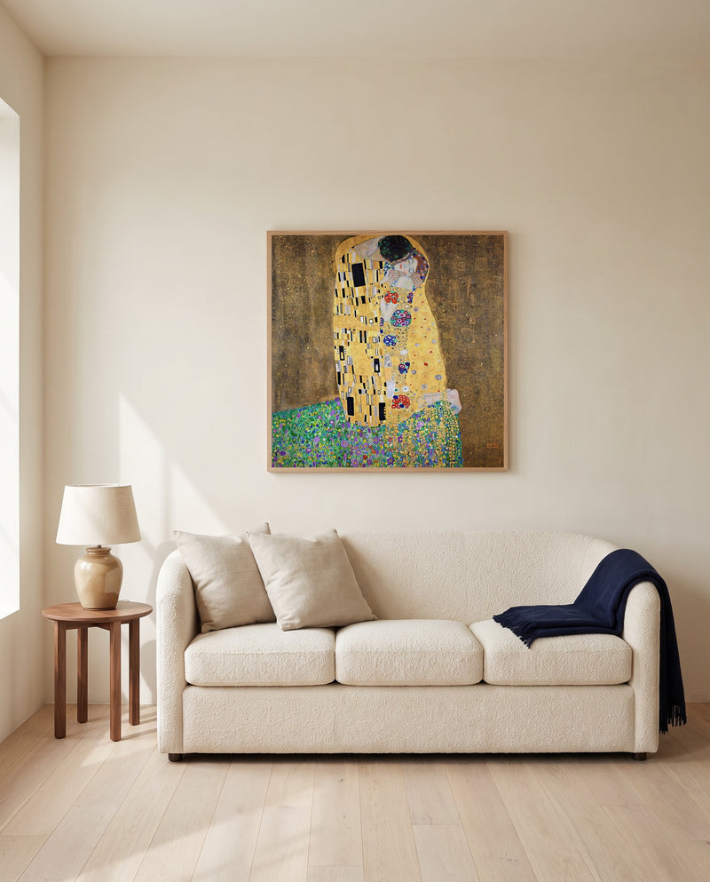 The Kiss by Gustav Klimt framed in natural oak above a cream sofa in a warm living room