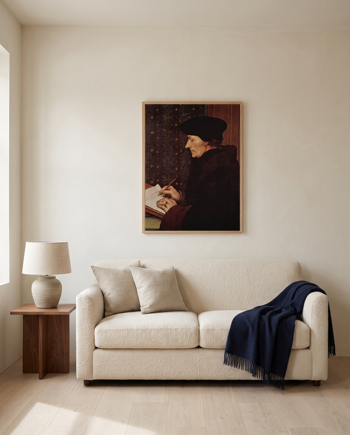 Erasmus Writing by Hans Holbein the Younger framed in natural oak above a cream sofa in a warm living room