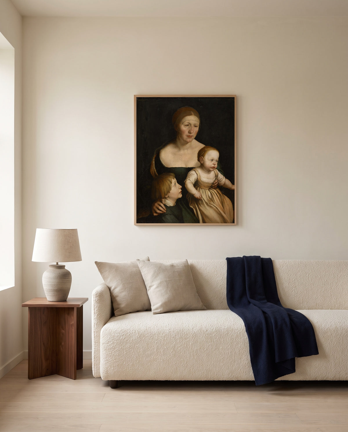 The Artist’s Family by Hans Holbein the Younger framed in natural oak above a cream sofa in a warm living room