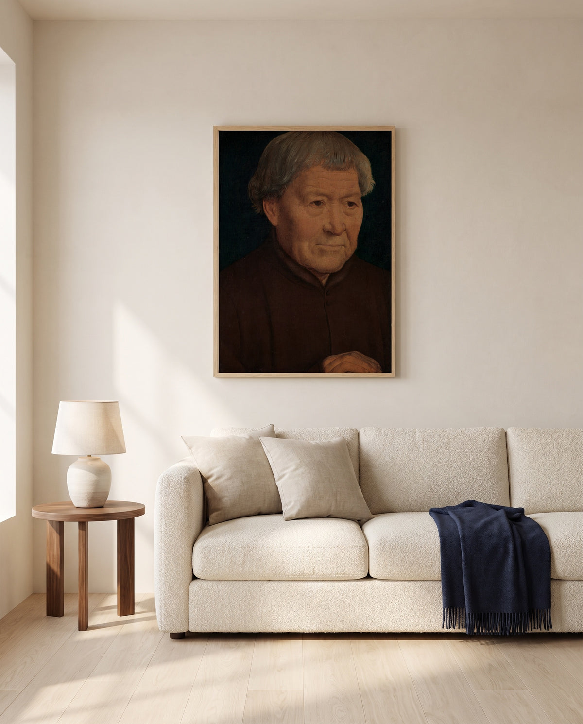 Old Man by Hans Memling framed in natural oak above a cream sofa in a warm living room