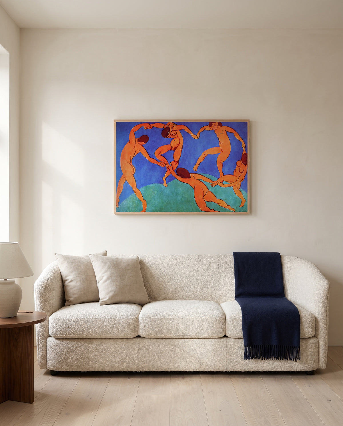 Dance (II) by Henri Matisse framed in natural oak above a cream sofa in a warm living room