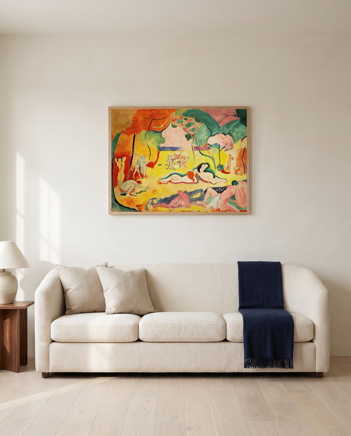 The Joy of Life by Henri Matisse framed in natural oak above a cream sofa in a warm living room