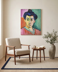 The Green Stripe by Henri Matisse as a stretched canvas above a linen lounge chair in a reading corner