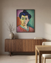 The Green Stripe by Henri Matisse in a black frame above a walnut sideboard in a dining room