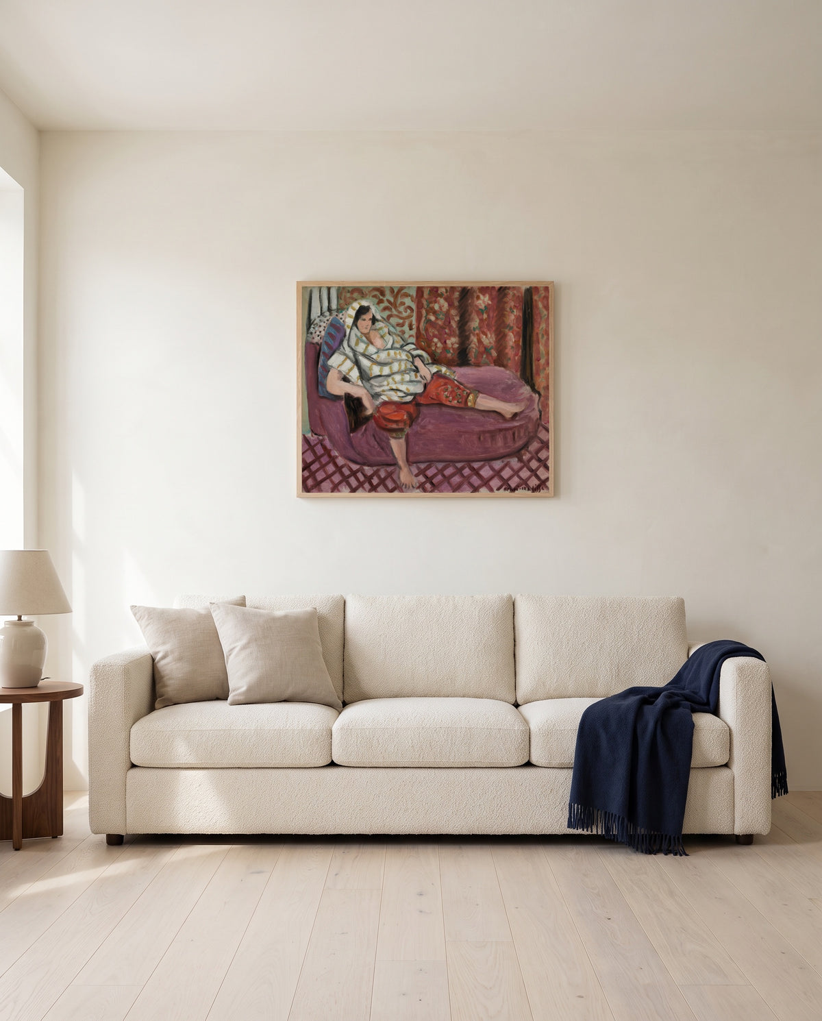 Woman on Rose Divan by Henri Matisse framed in natural oak above a cream sofa in a warm living room