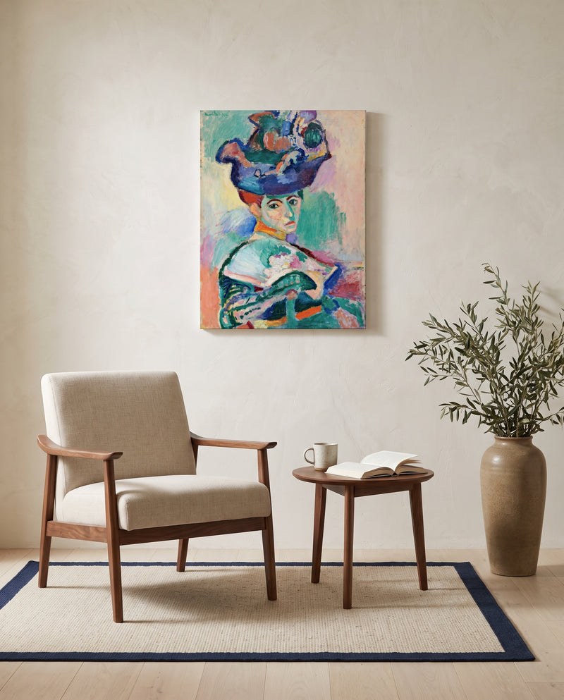 Woman with a Hat by Henri Matisse as a stretched canvas above a linen lounge chair in a reading corner