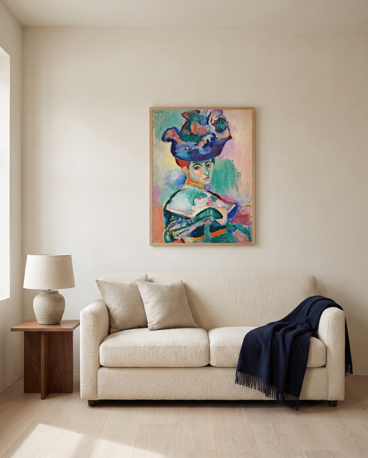 Woman with a Hat by Henri Matisse framed in natural oak above a cream sofa in a warm living room