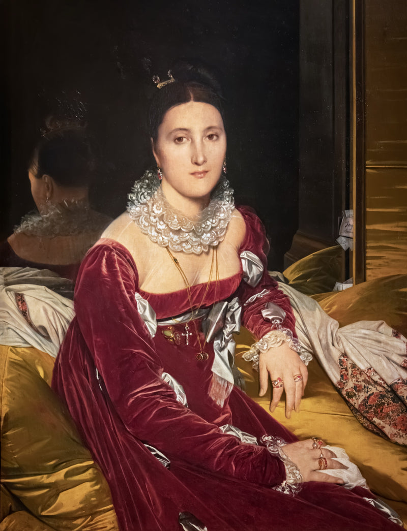 Madame de Senonnes by Ingres: a dark-haired woman in a red velvet gown with a lace collar on a gold sofa, a mirror behind