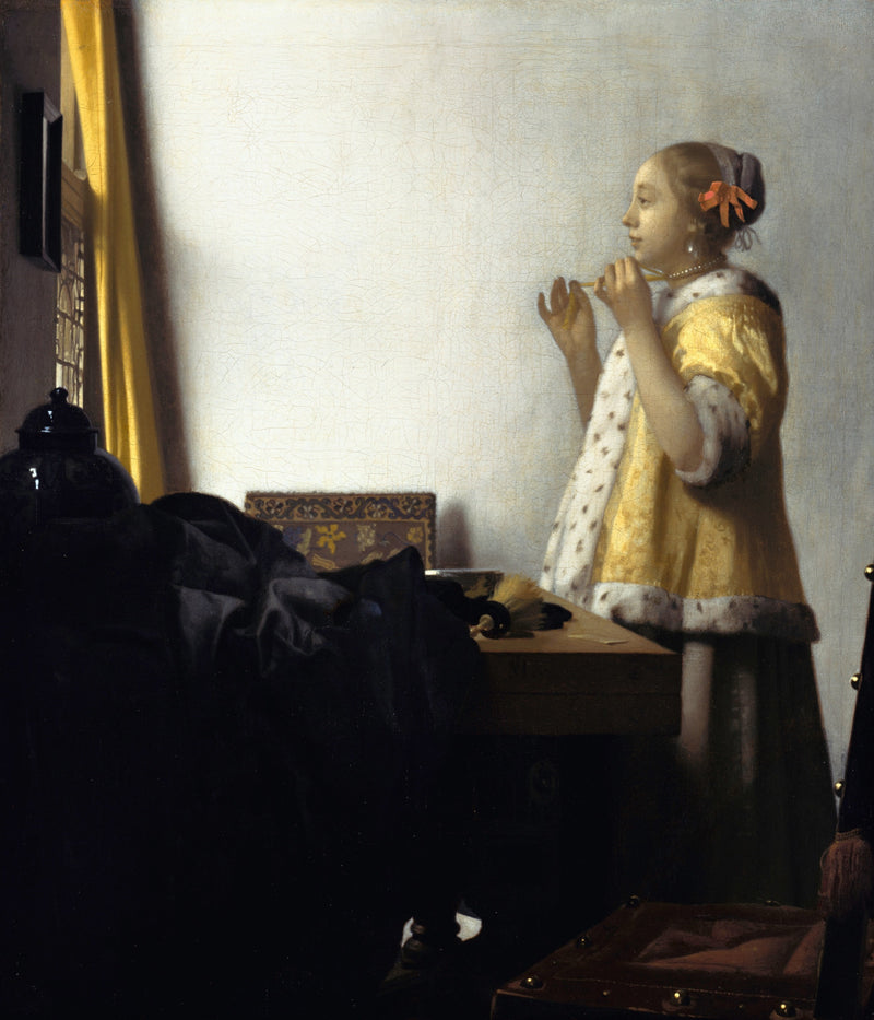 Woman with a Pearl Necklace by Vermeer: a young woman in a yellow fur-trimmed jacket holds up her pearls by a window