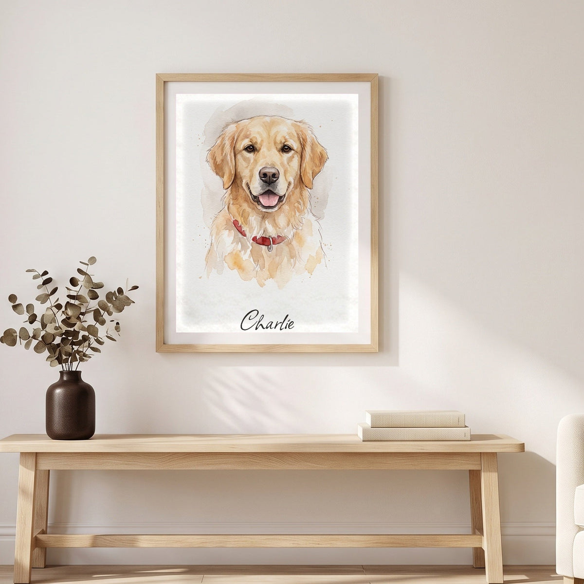 A framed watercolor portrait of a golden retriever named Charlie above a light oak bench