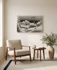 Evening Snow at Kambara by Utagawa Hiroshige as a stretched canvas above a linen lounge chair in a reading corner