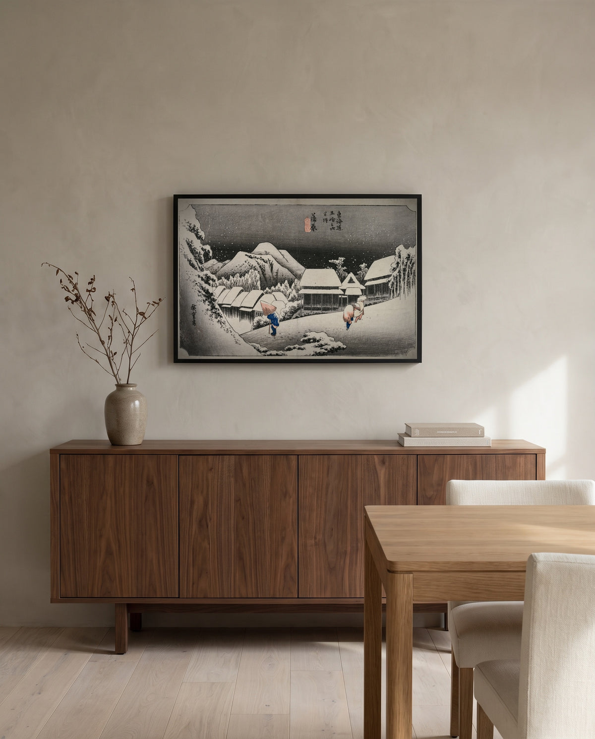 Evening Snow at Kambara by Utagawa Hiroshige in a black frame above a walnut sideboard in a dining room