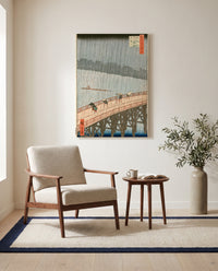 Sudden Shower at Ōhashi by Utagawa Hiroshige as a stretched canvas above a linen lounge chair in a reading corner
