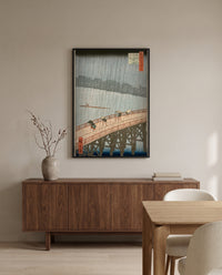 Sudden Shower at Ōhashi by Utagawa Hiroshige in a black frame above a walnut sideboard in a dining room