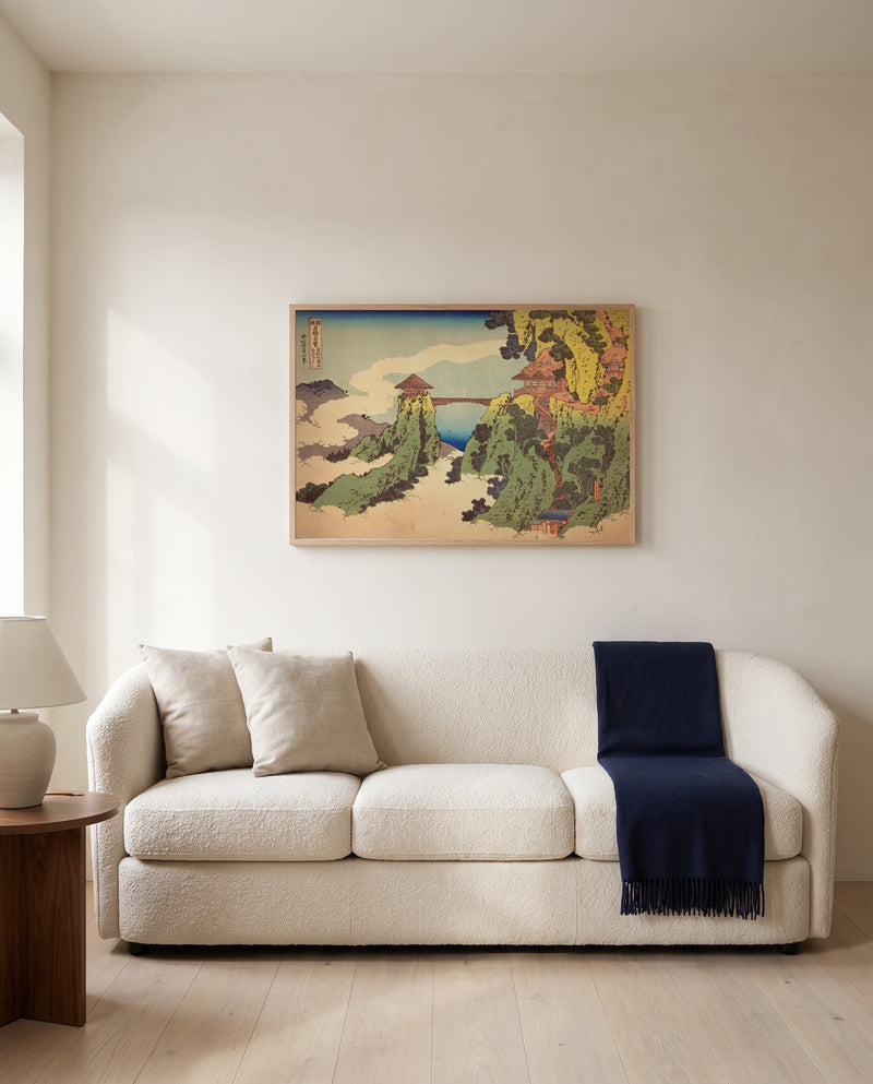 The Hanging-Cloud Bridge by Katsushika Hokusai framed in natural oak above a cream sofa in a warm living room