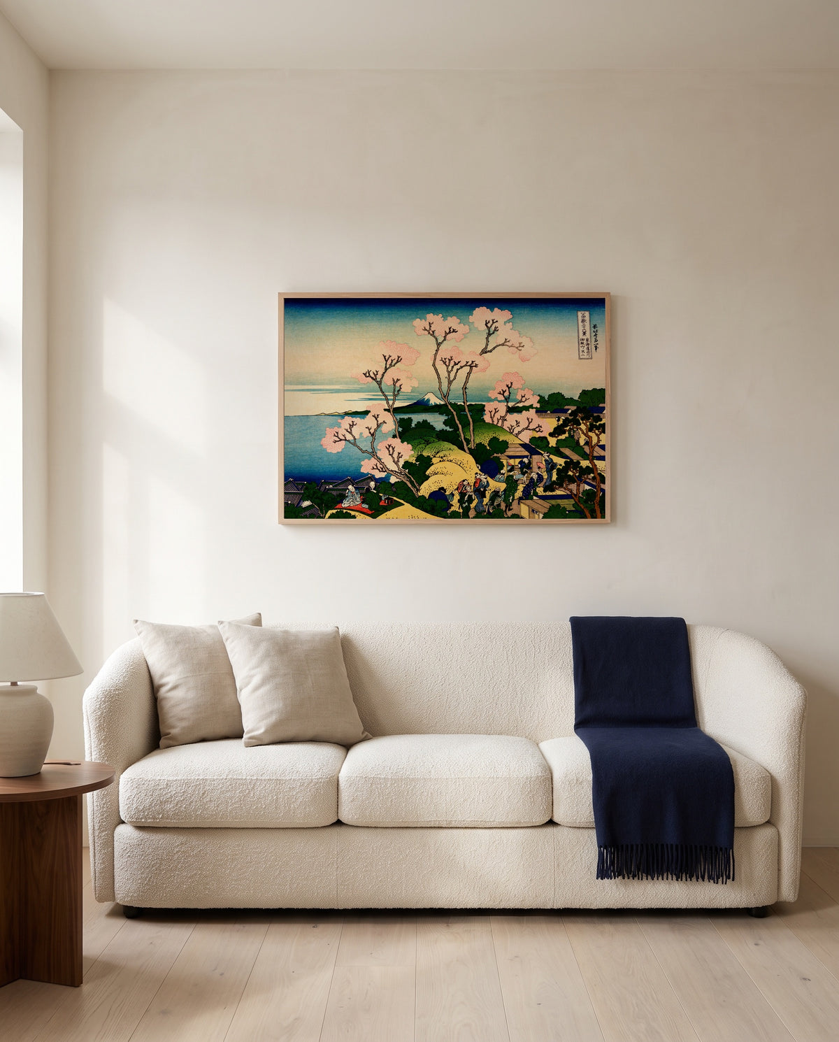 Goten Hill at Shinagawa by Katsushika Hokusai framed in natural oak above a cream sofa in a warm living room