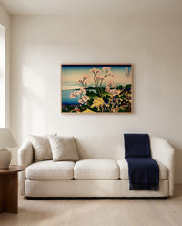 Goten Hill at Shinagawa by Katsushika Hokusai framed in natural oak above a cream sofa in a warm living room
