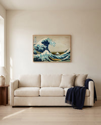 The Great Wave of Kanagawa by Katsushika Hokusai framed in natural oak above a cream sofa in a warm living room