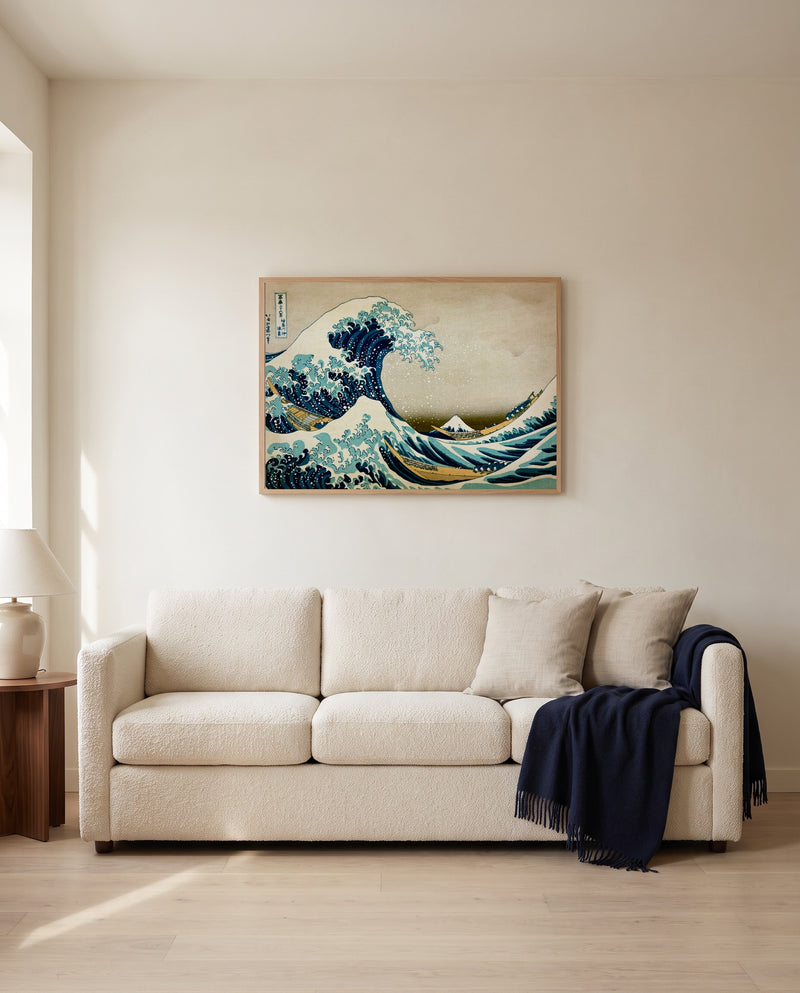 The Great Wave of Kanagawa by Katsushika Hokusai framed in natural oak above a cream sofa in a warm living room