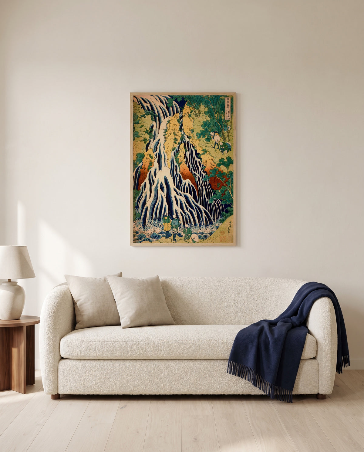 Kirifuri Waterfall by Katsushika Hokusai framed in natural oak above a cream sofa in a warm living room