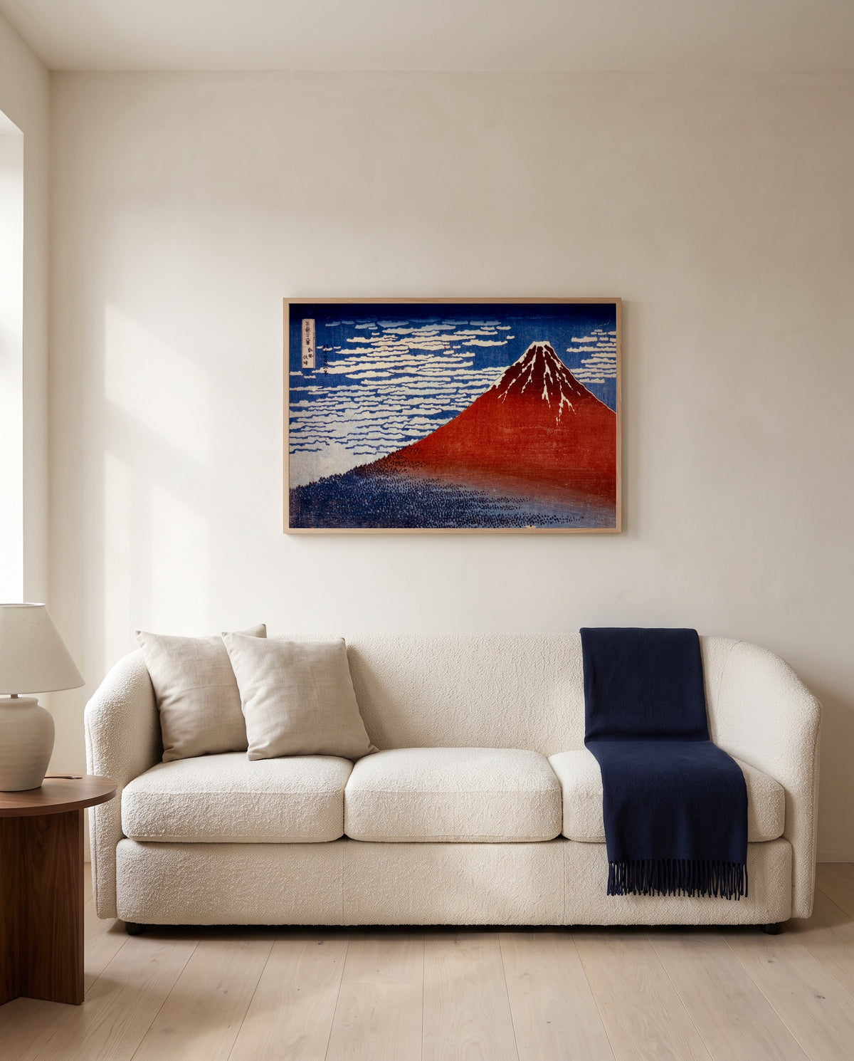 Red Fuji by Katsushika Hokusai framed in natural oak above a cream sofa in a warm living room