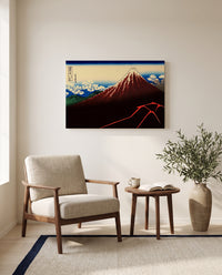 Thunderstorm Beneath the Summit by Katsushika Hokusai as a stretched canvas above a linen lounge chair in a reading corner