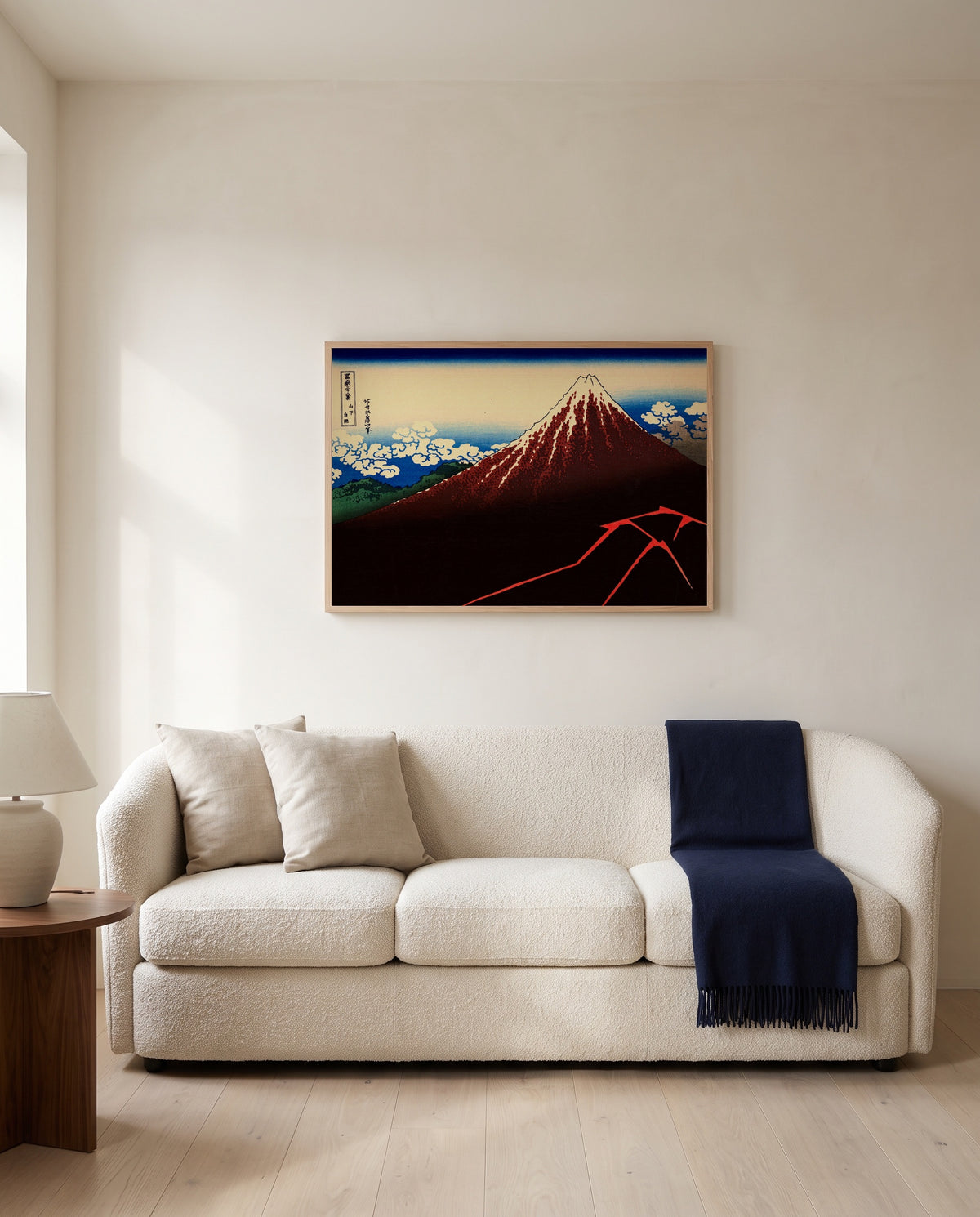 Thunderstorm Beneath the Summit by Katsushika Hokusai framed in natural oak above a cream sofa in a warm living room