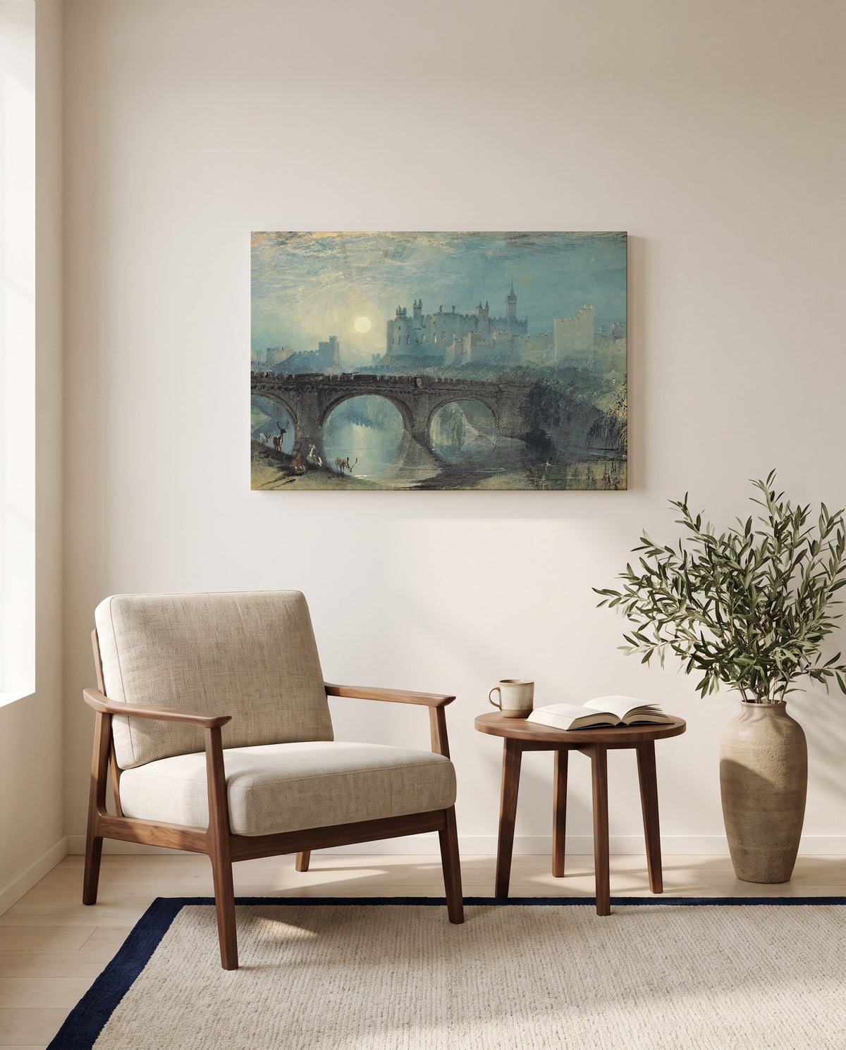 Alnwick Castle by J. M. W. Turner as a stretched canvas above a linen lounge chair in a reading corner